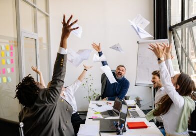 a group of people at work throwing papers