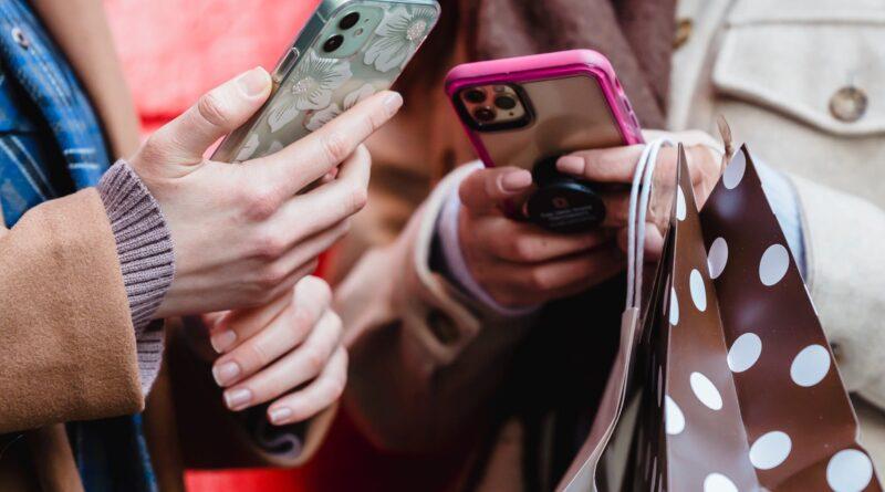 unrecognizable ladies messaging smartphones on street