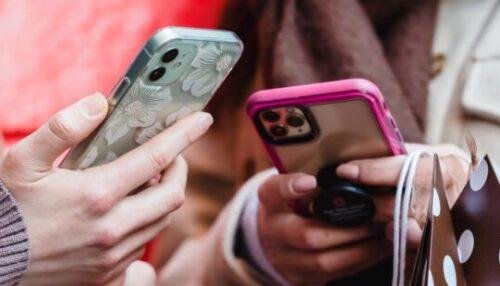 unrecognizable ladies messaging smartphones on street