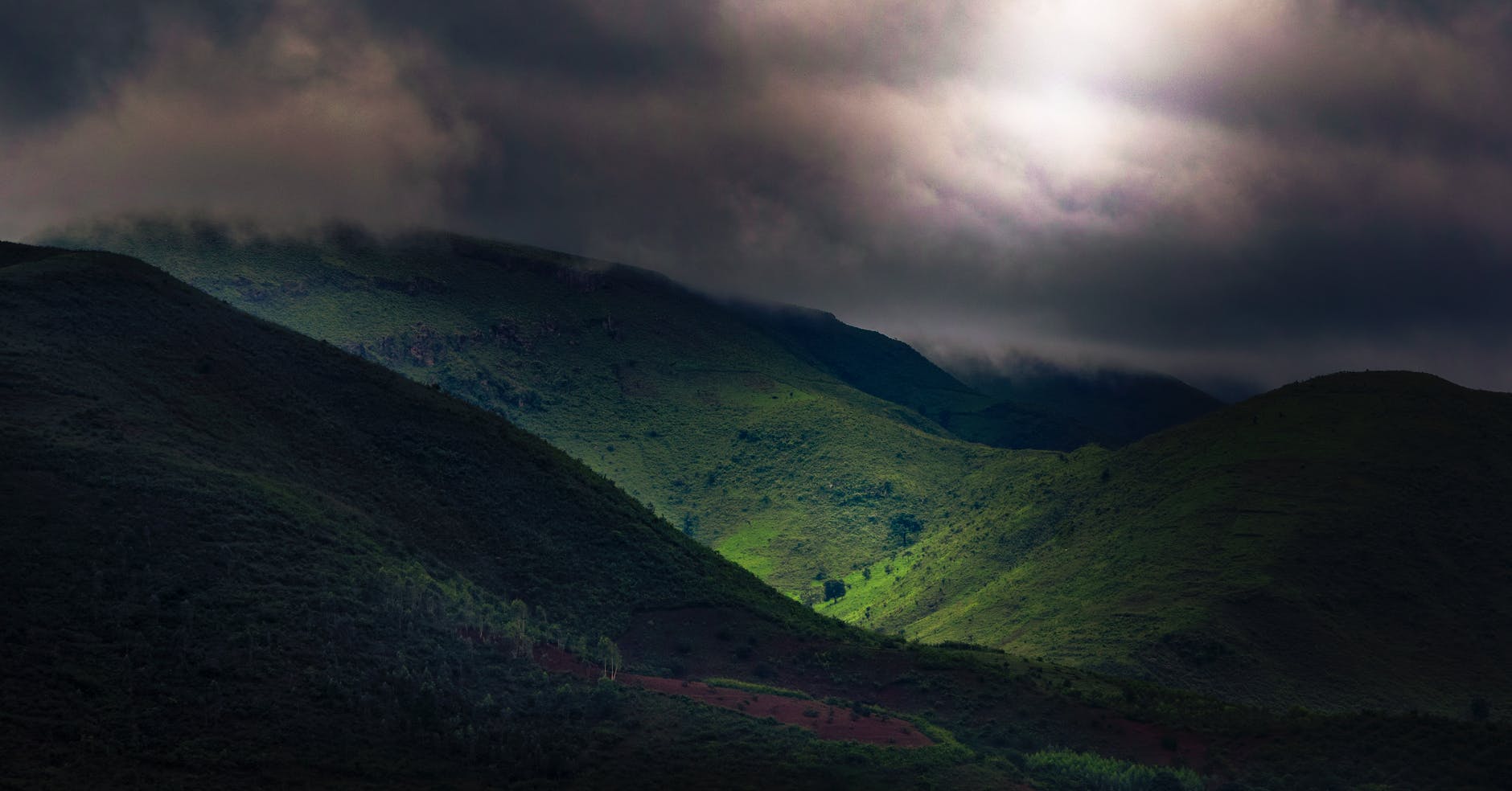 green mountains under dark sky