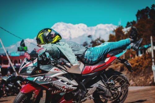 man in green jacket riding red and black sports bike