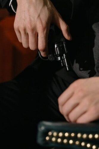 photo of person in black suit holding gun