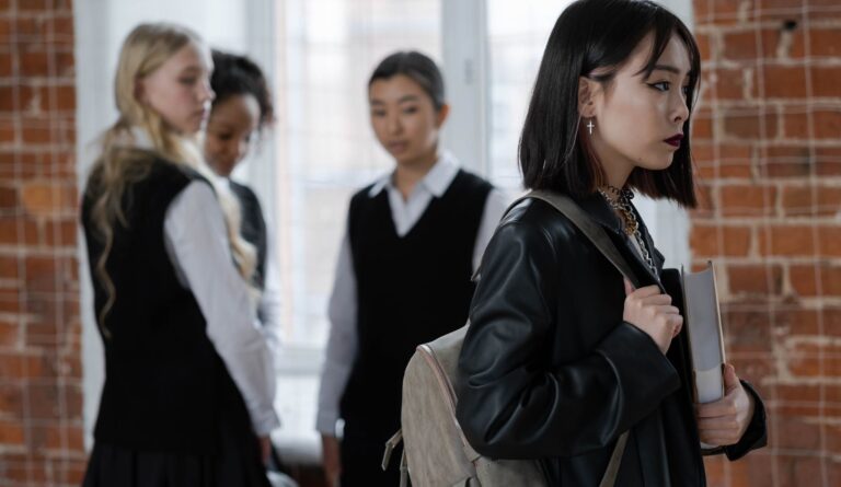 shallow focus of a girl in black leather jacket holding a book