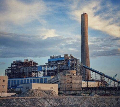thermal power plant near a river under cloudy sky