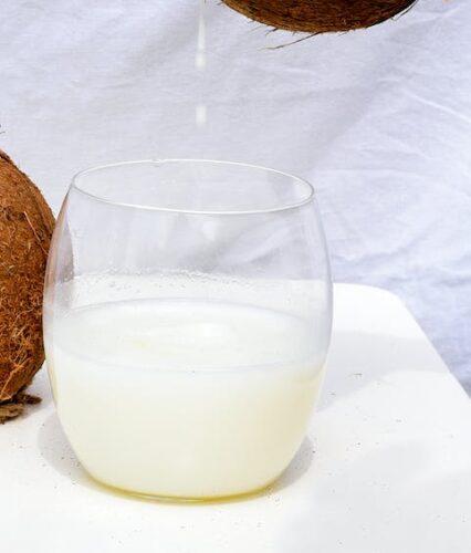 person pouring drink from coconut